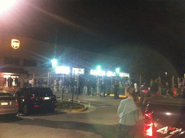 Customers who missed their delivery wait in line for the iPhone 4s