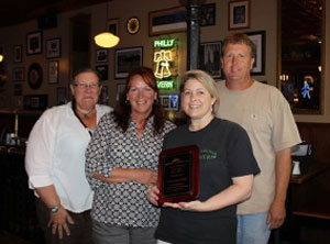Leporatti is presented a plaque from Historic Manassas Inc. From left, Vice President Chris Finnie, Executive Director Debbie Haight, Kari Leporatti, and President Mark Olsen. [Submitted photo]