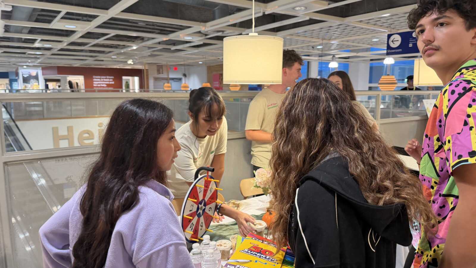 Students gather around a game table at the Woodbridge IKEA