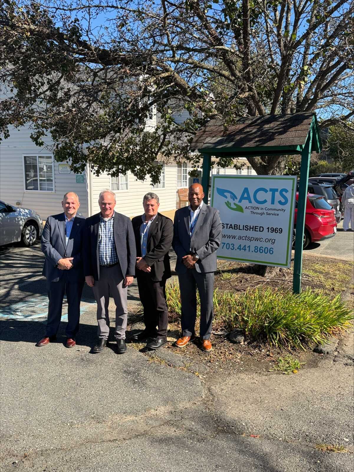 Sen. Tim Kaine and ACTS leaders by the ACTS sign