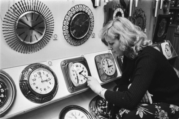 Woman adjusting a clock in a 1978 archive photo