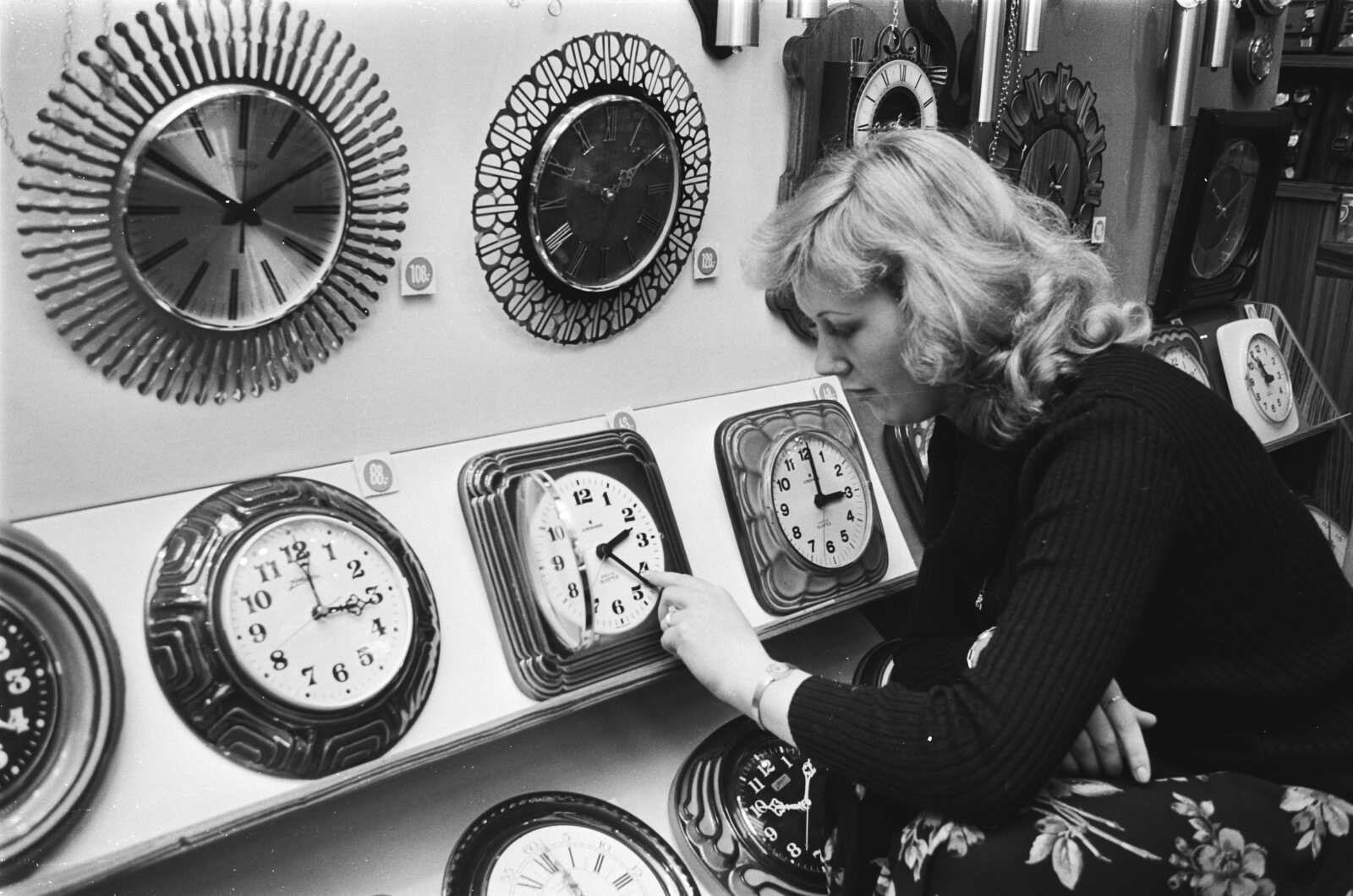 Woman adjusting a clock in a 1978 archive photo