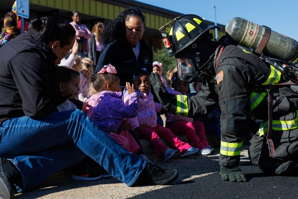 A child high-fives Quantico firefighter Curt Reifsteck