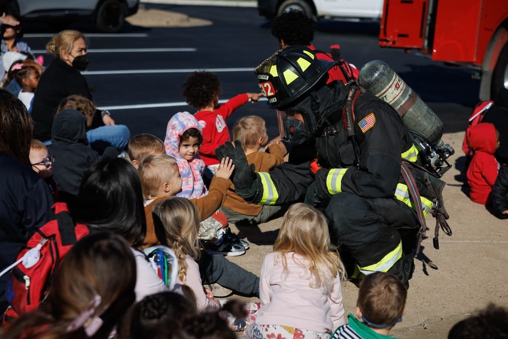 A child high-fives Quantico firefighter Curt Reifsteck